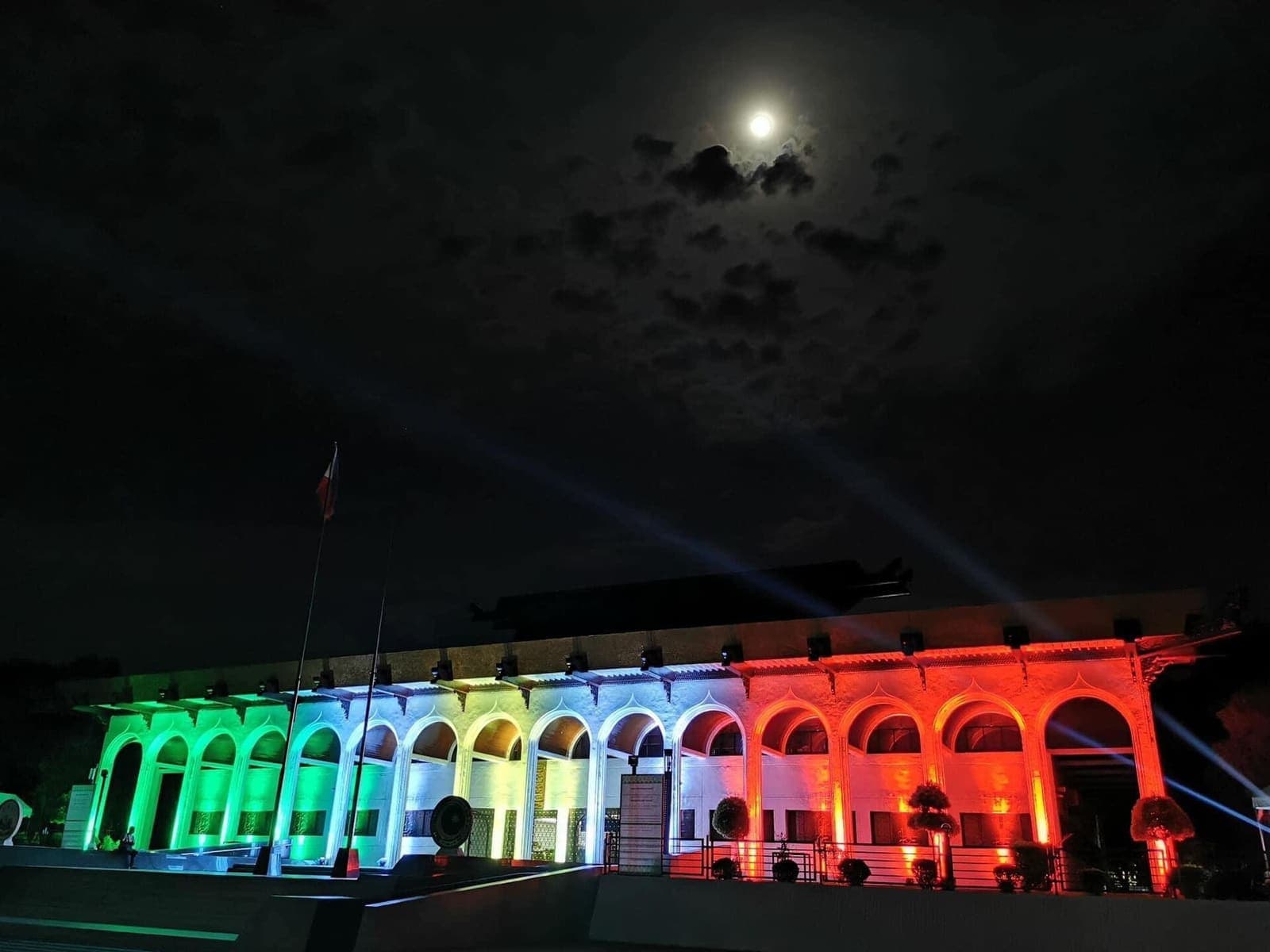 The arcade of the Bangsamoro Government Center at night, lit in bands of colored light.