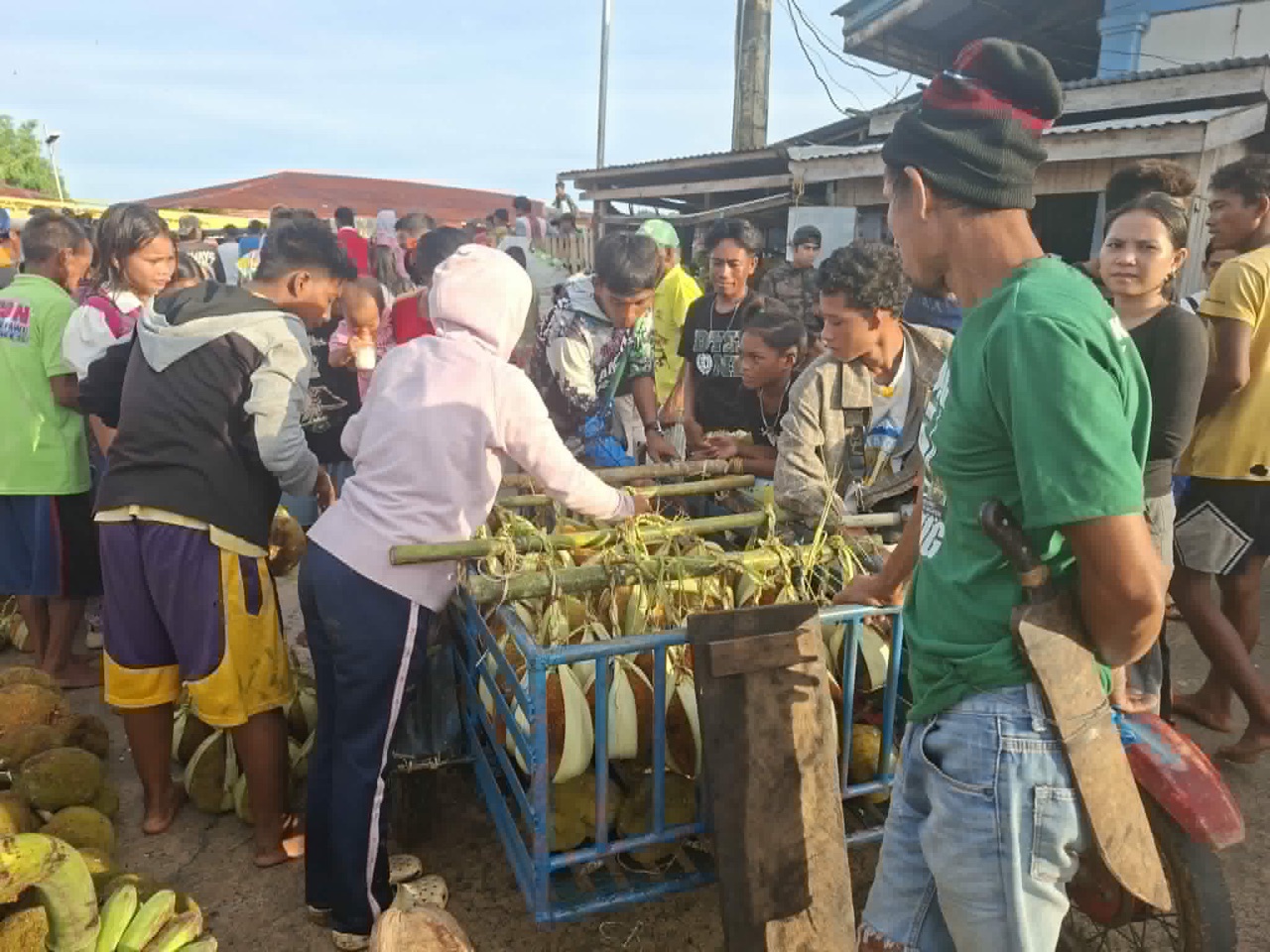 Shoppers crowd round a cart of freshly harvested marang at the Adlaw Pagtabuh-tabuh market.